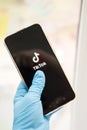 Tver, Russia-may 7, 2020, the tik tok logo on the smartphone screen in hands. Hands in medical gloves, the concept of coronavirus