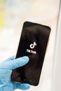 Tver, Russia-may 7, 2020, the tik tok logo on the smartphone screen in hands. Hands in medical gloves, the concept of coronavirus