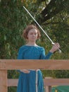 A girl in a long dress demonstrates her sword skills Royalty Free Stock Photo