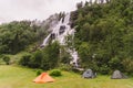 Tvinde Camping tents on the background of a waterfall Tvindefossen in Norway near Voss. Campsite in the norwegian fjords