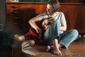 Tween girl and her mother sitting on the floor in living room at home, child looking on reflection Royalty Free Stock Photo