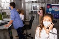 Tween girl in mask talking on telephone in quest room bunker Royalty Free Stock Photo