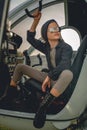 Tween girl in mirrored sunglasses sitting on pilots seat in open helicopter