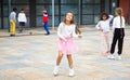 Tween girl in pink skirt jumping rope in schoolyard during recess Royalty Free Stock Photo