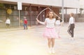 Tween girl in pink skirt jumping rope in schoolyard during recess Royalty Free Stock Photo