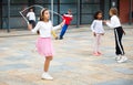 Tween girl in pink skirt jumping rope in schoolyard during recess Royalty Free Stock Photo