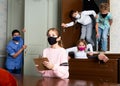 Tween girl in protective mask reading task in quest room Royalty Free Stock Photo