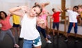 Tween girl training vigorous dance during group class