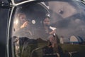 Tween girls in headsets sitting on pilot seats in helicopter