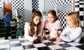 Tween girls solving conundrum in quest room stylized under chessboard