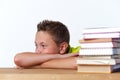 Tween pensive child sitting at table with books Royalty Free Stock Photo