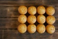Twelve delicious golden cupcakes lie on a wooden surface of pine planks. Tasty and healthy food. Daylight