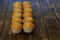 Twelve delicious golden cupcakes on a wooden surface of pine planks. Tasty and healthy food