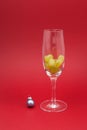 Twelve grapes in a glass for sparkling wine cava. Selective focus, red background, copy space. Spanish traditional to eat twelve Royalty Free Stock Photo