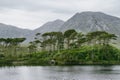 Twelve Pines Island on a gorgeous background formed by the sharp peaks of a mountain range called Twelve Pins or Twelve Bens,