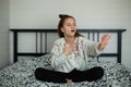 Twelve year old cute girl having fun in her room sitting on bed