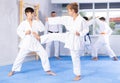 Twen boys in kimonos honing karate kicking techniques during kumite