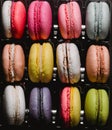 Twenty colorful macaroons set on black background. Closeup food photo