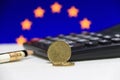 Twenty France euro cent on obverse on white floor with black calculator and pencil, European Union flag. Royalty Free Stock Photo