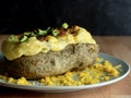 Twice Baked Potato Loaded with Scallions, Bacon and Cheddar Cheese Baked to Perfection on a Gray Plate Garnished with More Cheese Royalty Free Stock Photo