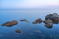 Twilght over the wild rocky beach coastline and the sea. Sea and rocks at night wide angle view. Royalty Free Stock Photo