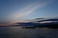 Twilight blue sky in cirrus clouds at sunset in a dark blue cloud on the horizon above the water of the lake Royalty Free Stock Photo