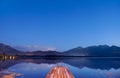 Twilight at lake Hopfensee in Bavaria with pier and mountains mirroring in water