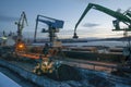 Loading of bulk cargo by cranes with manipulators into the hold of a sea ship Royalty Free Stock Photo