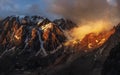 Majestic glacier is illuminated by the bright golden evening sun. Panoramic view. Altai Mountains