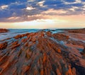 Twilight ocean coast with ribbed stratiform rock Royalty Free Stock Photo