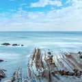 Twilight ocean coast with ribbed stratiform rock Royalty Free Stock Photo