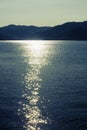 Twilight seascape. Mountains and sun glint in the water Royalty Free Stock Photo