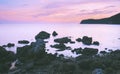 Twilight sky with dark rock beach