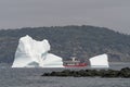 A tour boat passes an iceberg on a foggy day