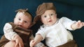 twin babies in retro clothes. brother and sister a twins kids sit on the couch in retro clothes cap play among lifestyle Royalty Free Stock Photo