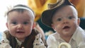 twin babies in retro clothes. brother and sister a twins kids sit on the couch in retro clothes cap play among Royalty Free Stock Photo