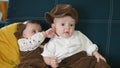 twin babies in retro clothes. brother and sister a twins kids sit on the couch in retro clothes cap play among Royalty Free Stock Photo