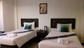 Twin Bedded Room. Bed with white bedding, decorated with pillows and blue Bed runner