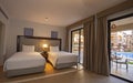 Twin beds in suite of a luxury hotel room with terrace and pool view Royalty Free Stock Photo