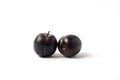 Twin black cherry plums isolated on white background