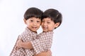 Twin boys hugging on white background. Portrait of little son hugging brother or friend. I missing you. Full length happy boy emb