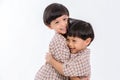 Twin boys hugging on white background. Portrait of little son hugging brother or friend. I missing you. Full length happy boy emb