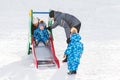 Twin brother rolls down hill, happy family winter walks in the Park Royalty Free Stock Photo