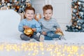 Twin brothers in front of the christmas tree with candles and gifts. love, happiness and big family concept Royalty Free Stock Photo