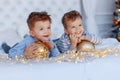 Twin brothers in front of the christmas tree with candles and gifts. love, happiness and big family concept Royalty Free Stock Photo