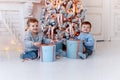 Twin brothers in front of the christmas tree with candles and gifts. love, happiness and big family concept Royalty Free Stock Photo