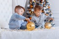 Twin brothers in front of the christmas tree with candles and gifts. love, happiness and big family concept Royalty Free Stock Photo