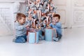 Twin brothers in front of the christmas tree with candles and gifts. love, happiness and big family concept Royalty Free Stock Photo