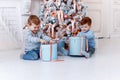 Twin brothers in front of the christmas tree with candles and gifts. love, happiness and big family concept Royalty Free Stock Photo