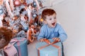 Twin brothers in front of the christmas tree with candles and gifts. love, happiness and big family concept Royalty Free Stock Photo